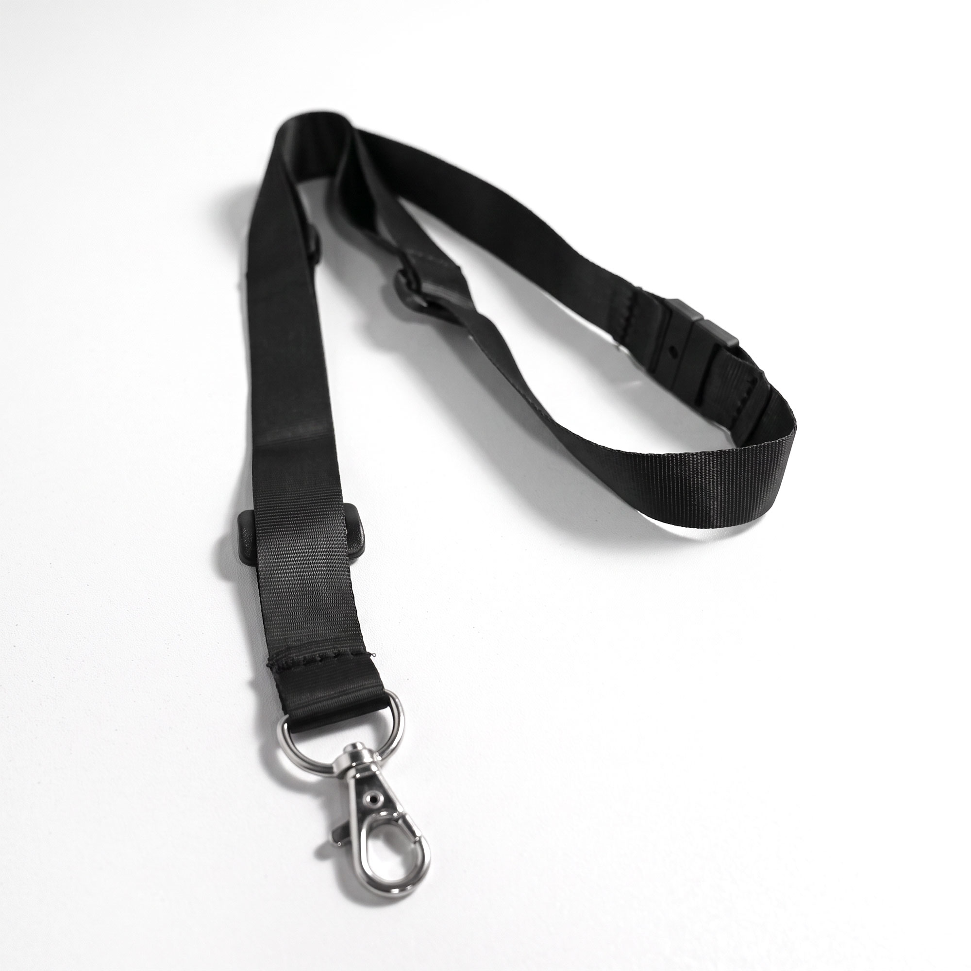 Full black RAZ neck lanyard laid flat, showing the metal clip, adjustable slider, and breakaway safety buckle.