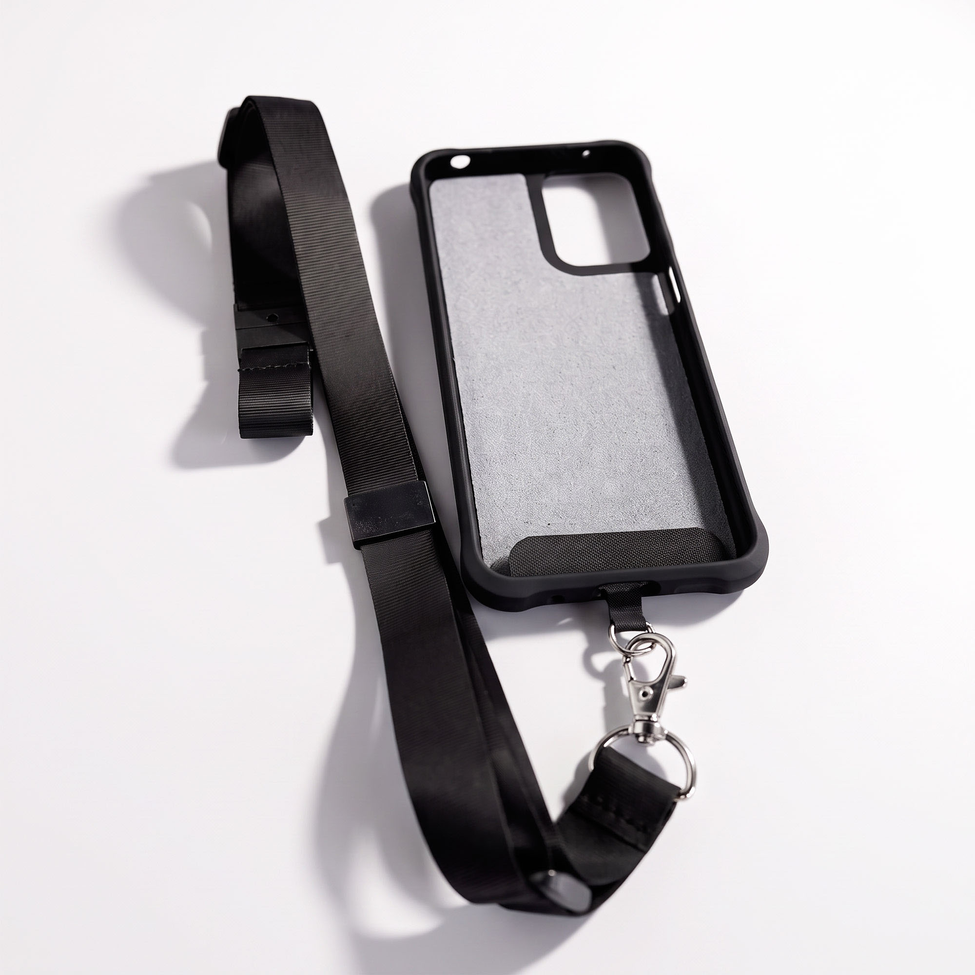 Black RAZ lanyard with plastic tip inserted into an empty black protective case, showing how the two attach.