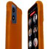 Close-up image of the RAZ Memory Cell Phone inside a high-visibility orange version of the Rugged Protective Case Blocking Buttons. The front screen shows six large contact buttons with names and photos—Cindy Miller, Michael, Peter Stevens, Anne Peters, Linda, and Cathy—along with a red “EMERGENCY” button at the top. The back of the phone reveals the textured orange case with side grips.