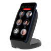 The RAZ Memory Cell Phone is shown upright on a wireless charging stand. The screen displays six large contact buttons with photos and names—Cindy Miller, Michael, Peter Stevens, Anne Peters, Linda Smith, and Cathy Clark—and a red “EMERGENCY” button at the top. The status bar indicates 74% battery, time (4:06 PM), and date (Wednesday, Nov 27).